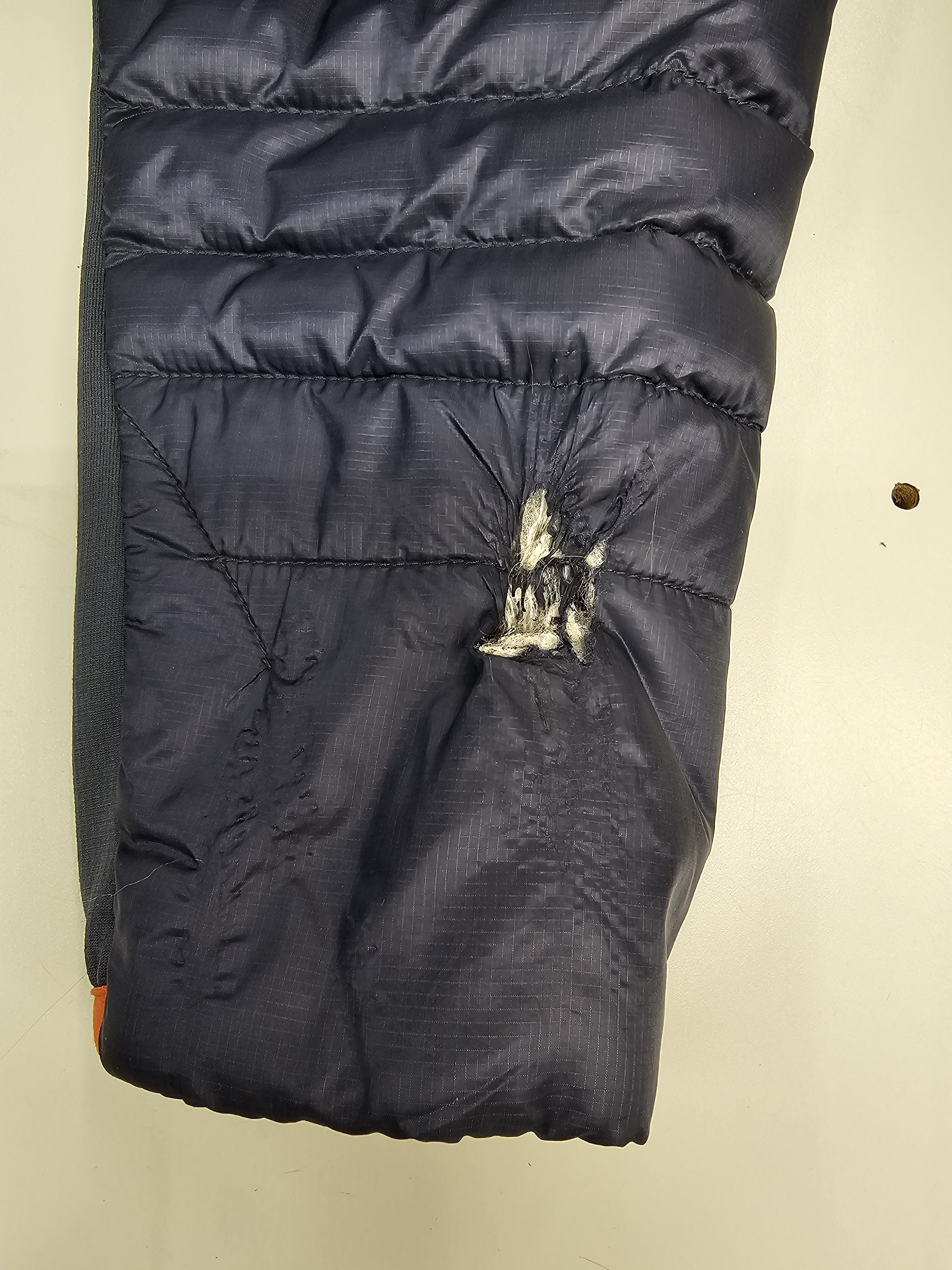 torn blue jacket sleeve damage